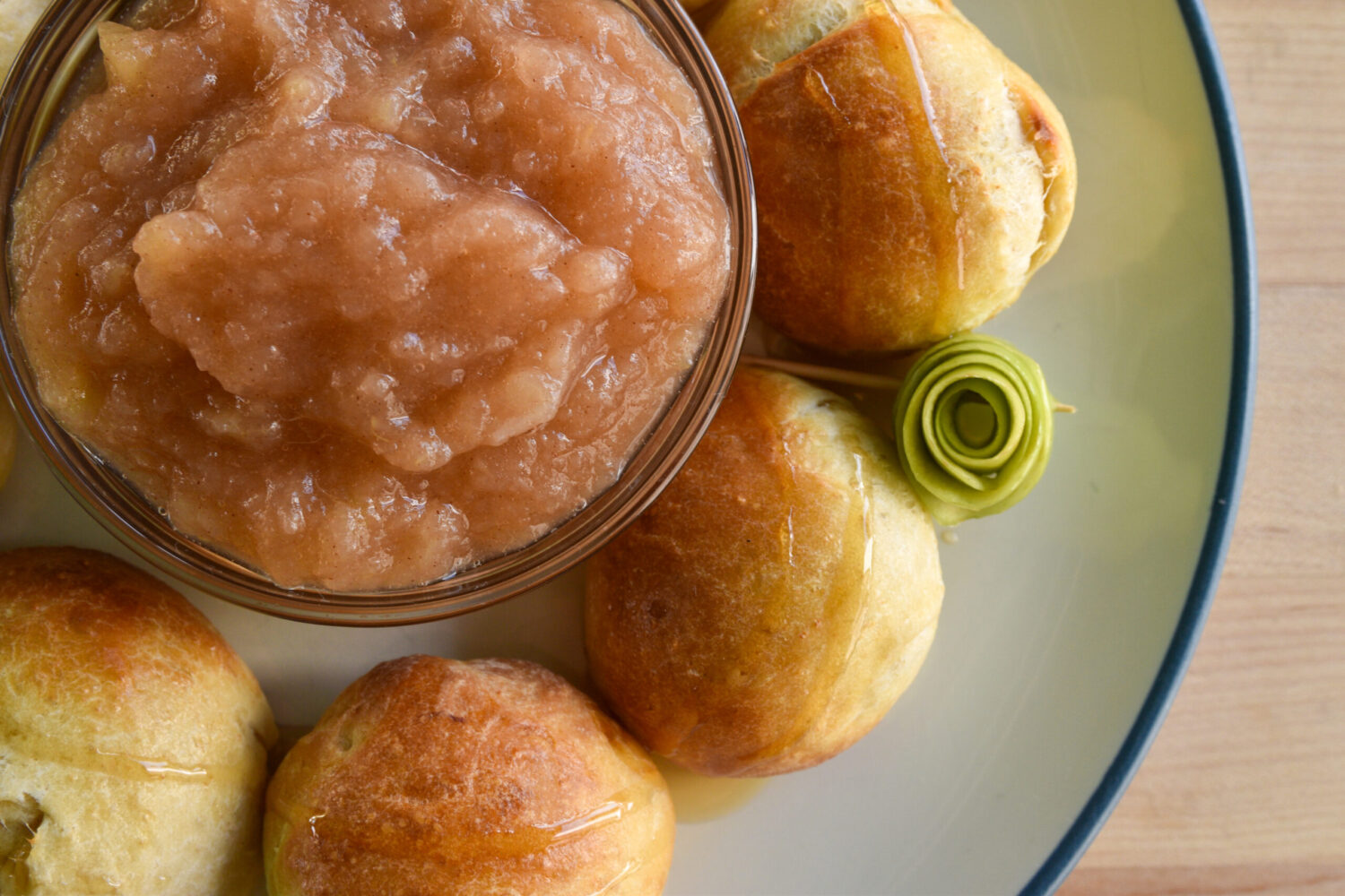 a bowl of applesauce surrounded by pieces of challah bread